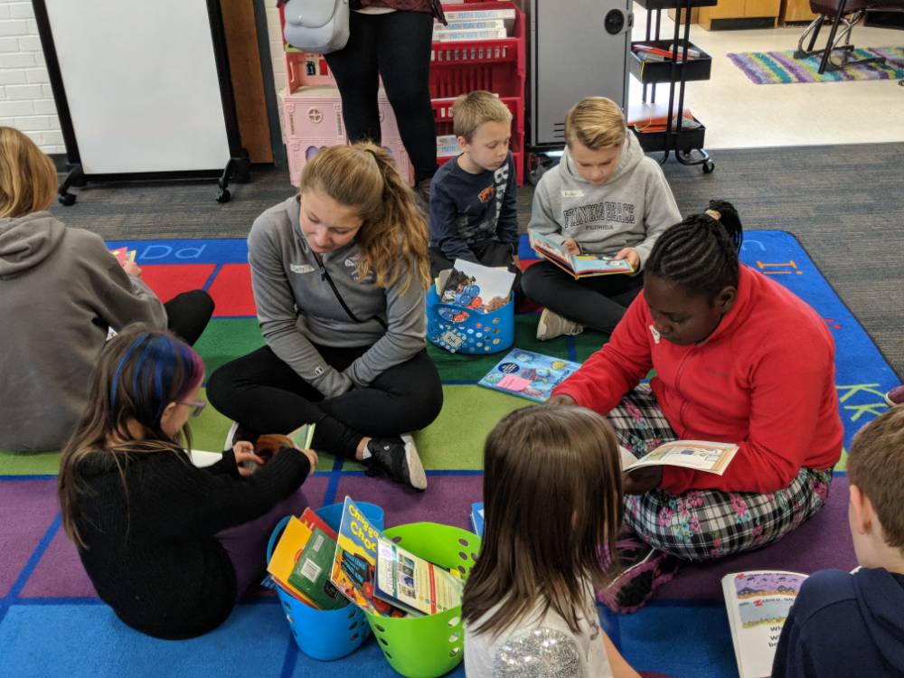 Central Woodlands lead a reading circle with kindergartners